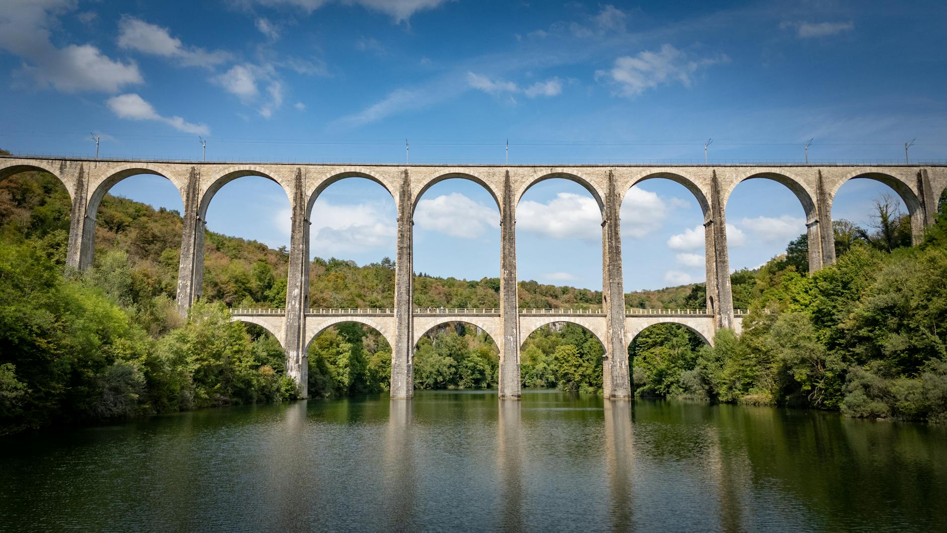 stunning viaduct bridge over lush river in corveissiat