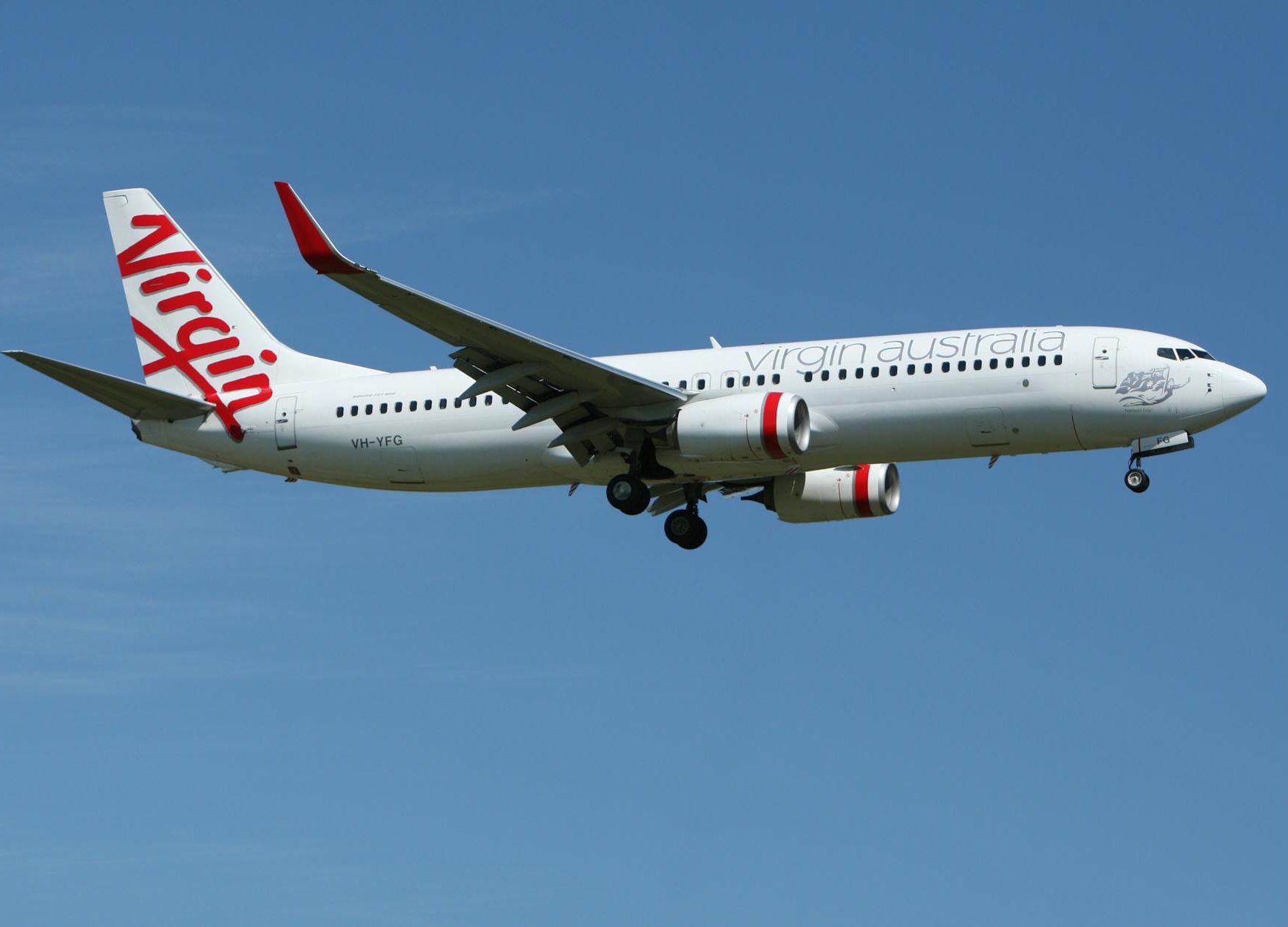 white and red virgin australia airplane mid air under blue and white sky during daytime